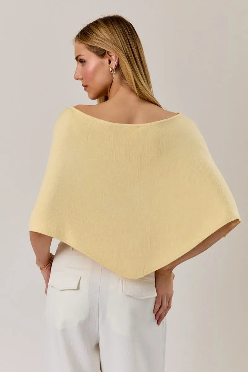 A soft pale yellow poncho knit top with slouchy neck line and wide open shoulder design and draped sleeves