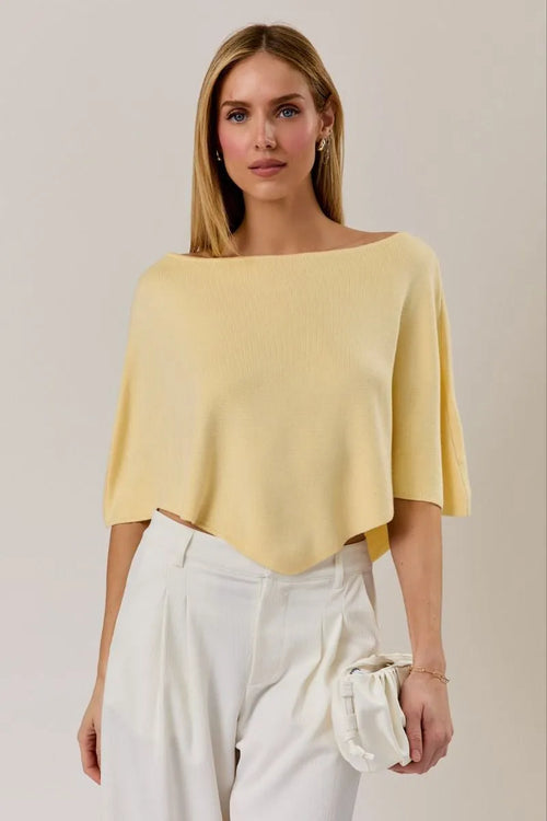 A soft pale yellow poncho knit top with a slouchy neck line and short flutter sleeves in a relaxed fit