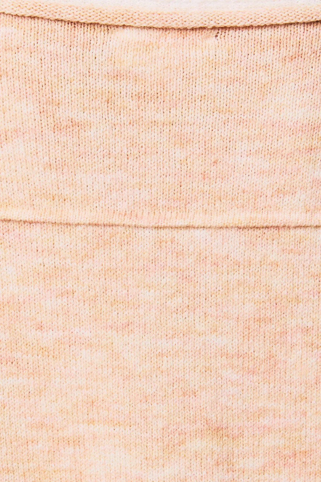 A soft peach-colored knit fabric with ribbed detailing on a contrast trim boat neck oversized knit sweater