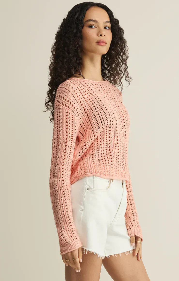 A soft pink cropped upland crochet sweater with long sleeves and an openwork knitted pattern