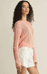 A soft pink cropped upland crochet sweater with long sleeves and an openwork knitted pattern