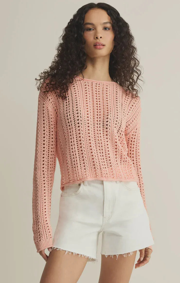 A soft pink upland crochet sweater featuring a long-sleeved openwork pattern and cropped fit knit design