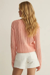 A soft pink upland crochet sweater with long sleeves openwork pattern and ribbed hem knit for comfort