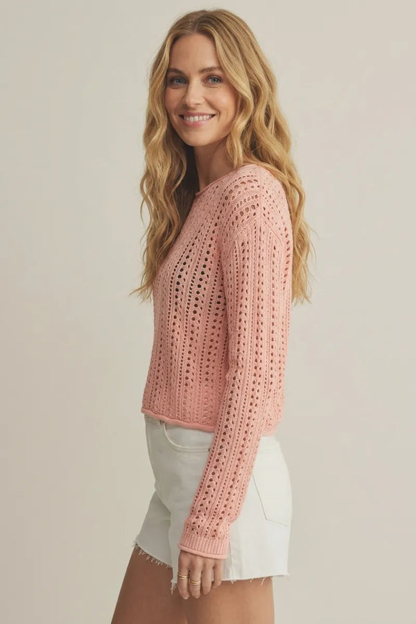 A soft pink upland crochet sweater with long sleeves and an openwork pattern in a knitted design