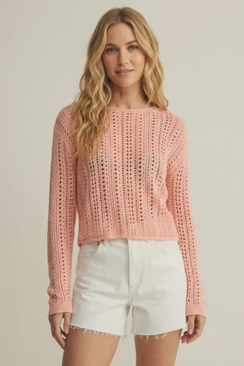 A soft pink upland crochet sweater featuring a long-sleeved knitted design with textured openwork and ribbed cuffs