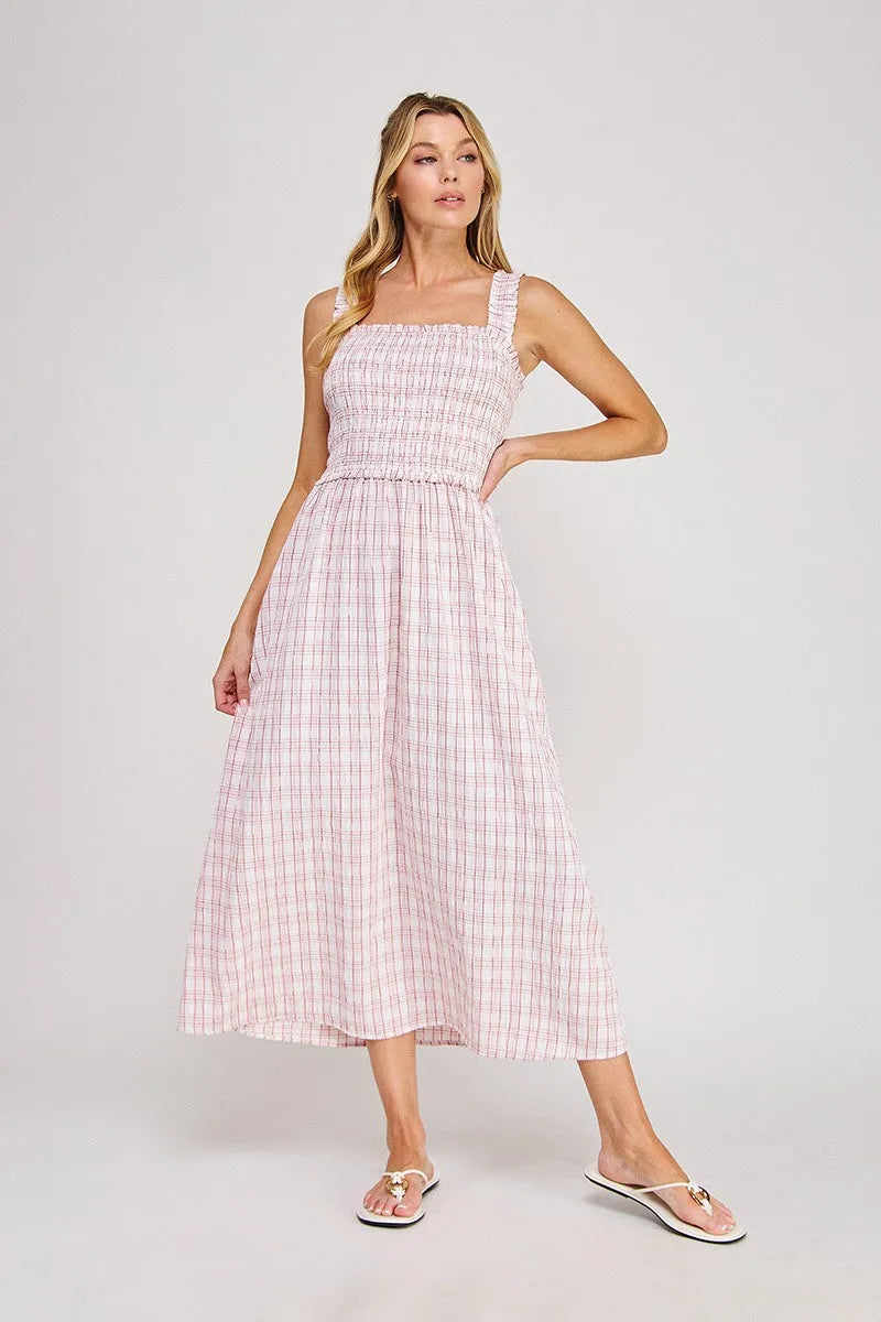 A soft pink and white plaid print smocked midi dress with square neckline and flowing skirt