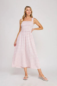 A soft pink and white plaid print smocked midi dress with square neckline and flowing skirt