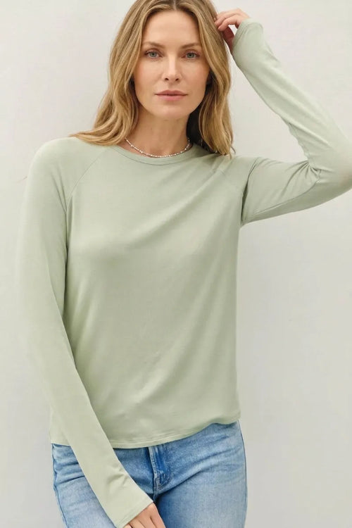 A soft sage green modal raglan sleeve long-sleeved top with a relaxed fit for layering basics