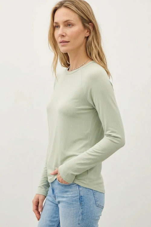 A soft sage green modal raglan sleeve long-sleeved top with round neckline and subtle side seam detailing