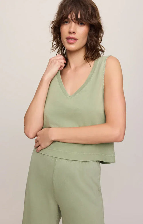 A soft sage green v neck cotton jersey tank top with sleeveless design and peplum hem for casual wear