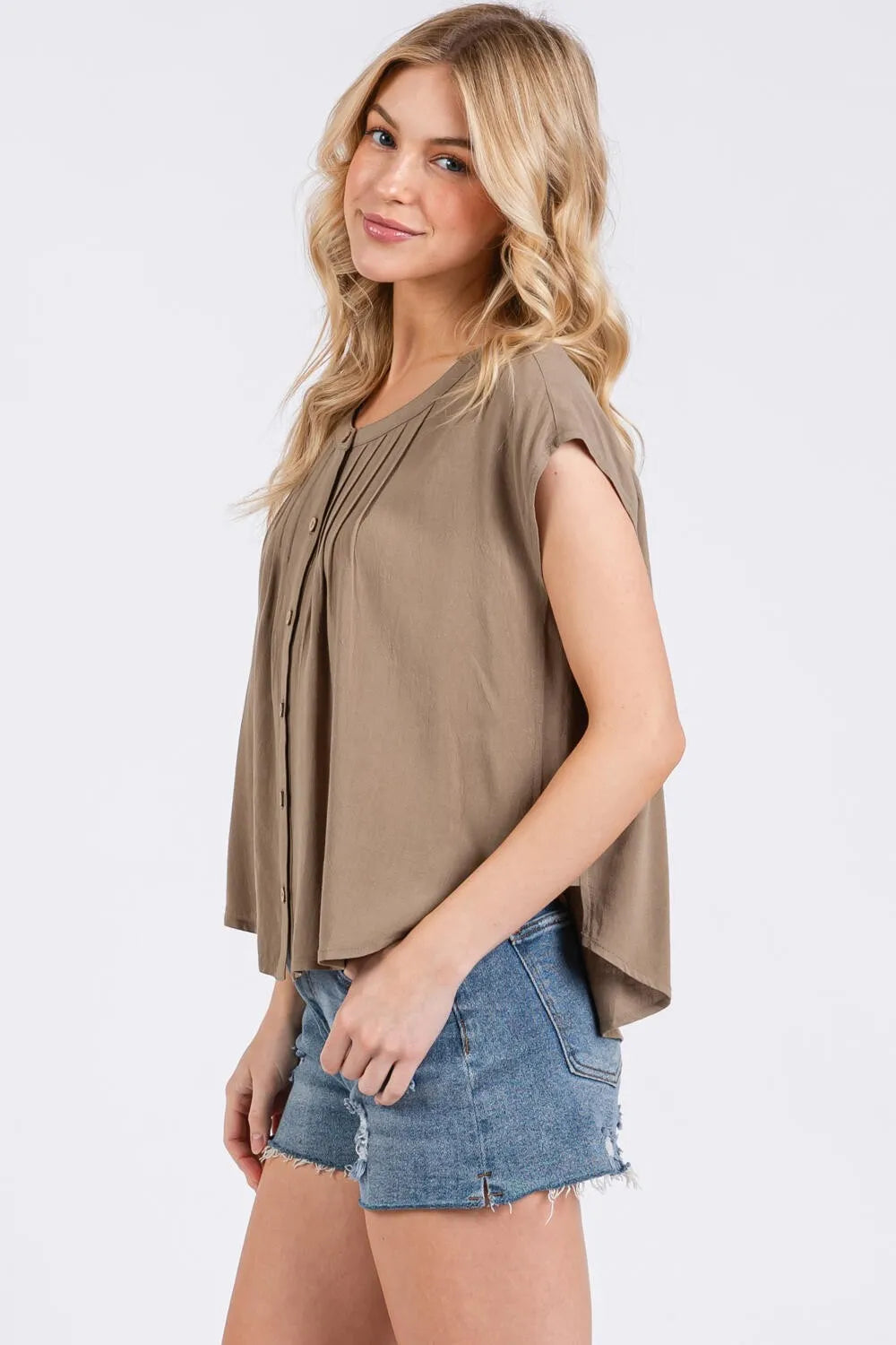 A soft taupe sleeveless blouse with pintuck detailed button front and pleated design for elegant wear