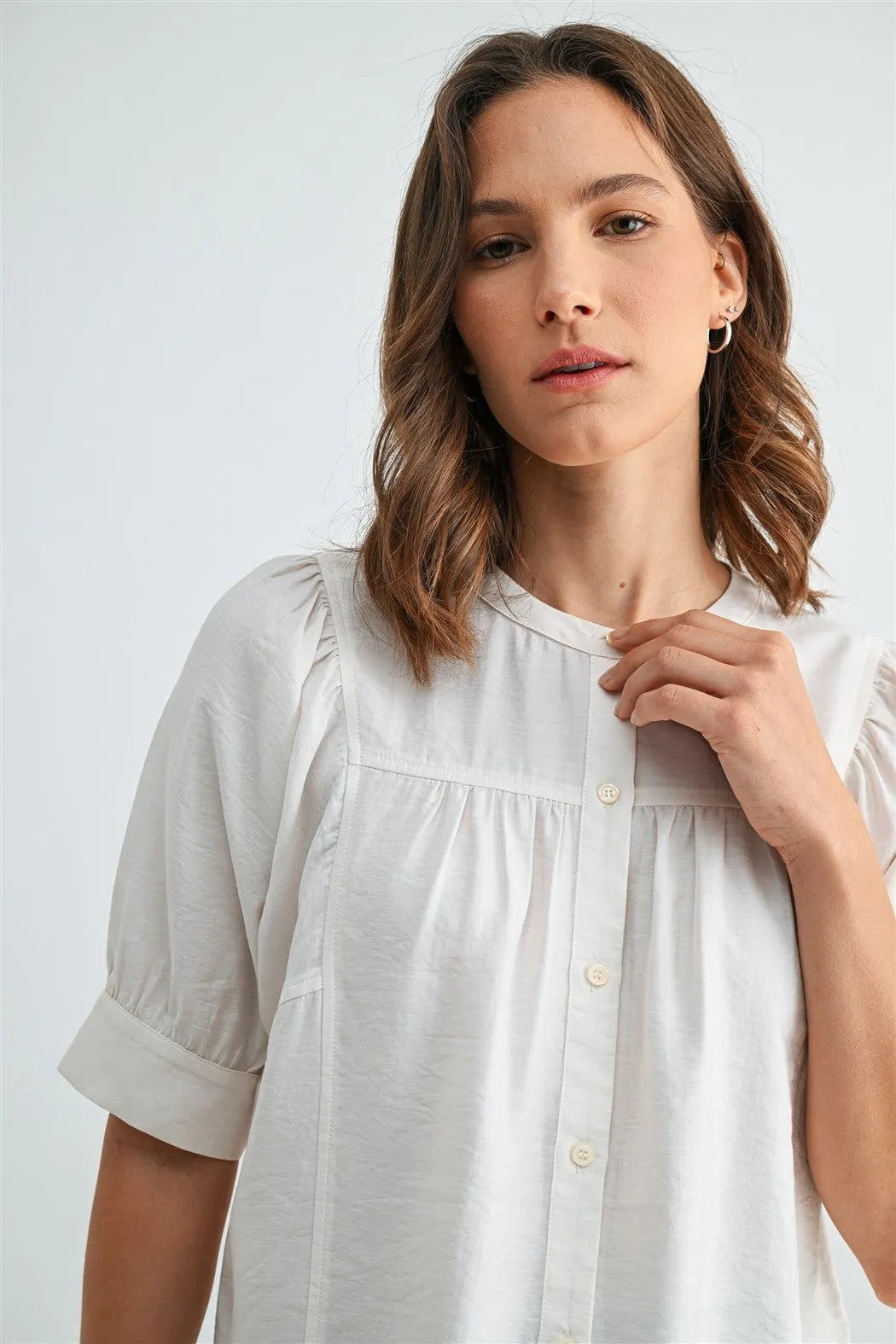 A soft white cotton button down short sleeve blouse with puffed sleeves for a stylish summer look