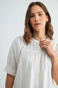 A soft white cotton button down short sleeve blouse with puffed sleeves for a stylish summer look