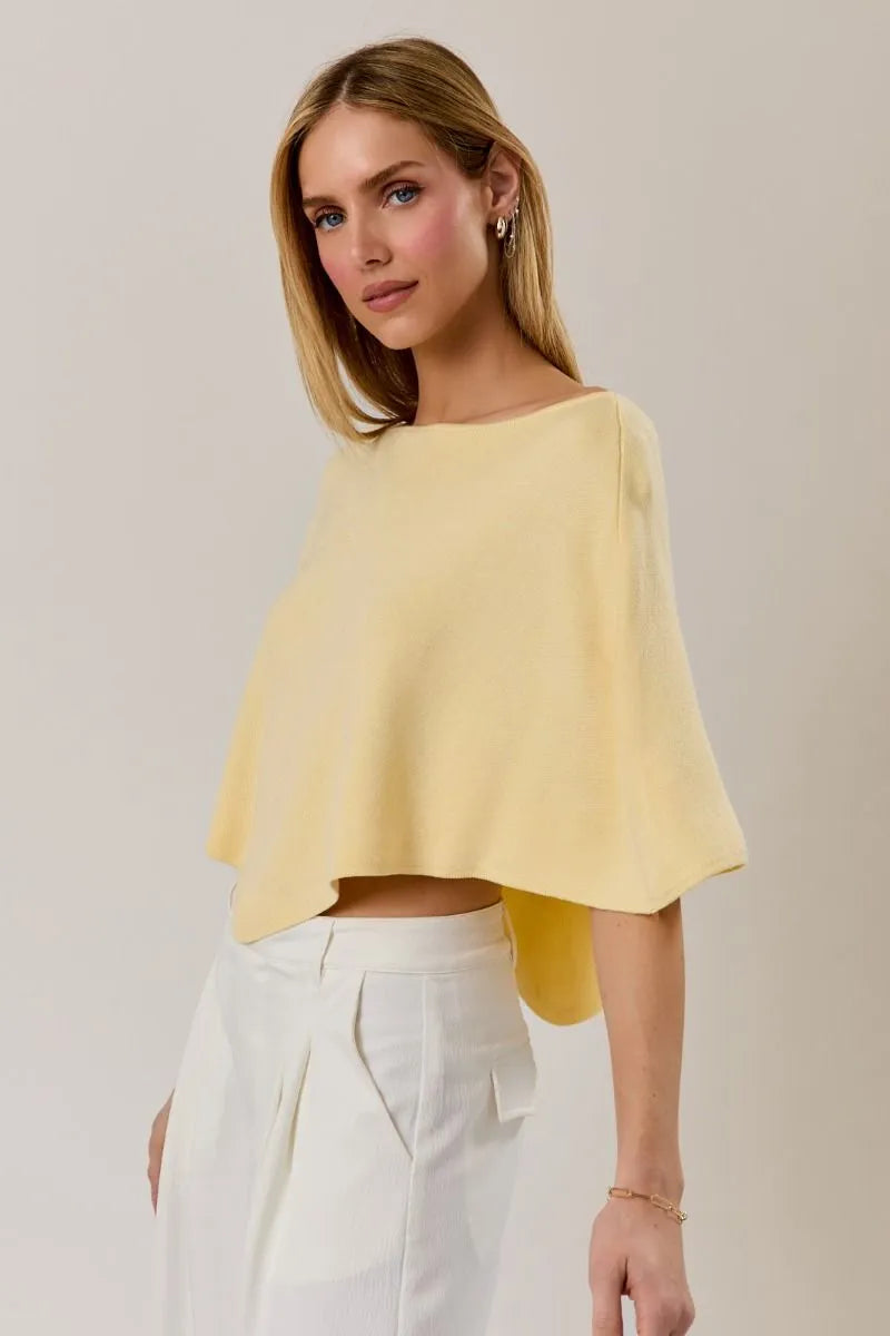 A soft yellow poncho knit top with a slouchy neck line and wide sleeves in a relaxed cape style