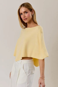A soft yellow poncho knit top with a slouchy neck line and wide sleeves in a relaxed cape style