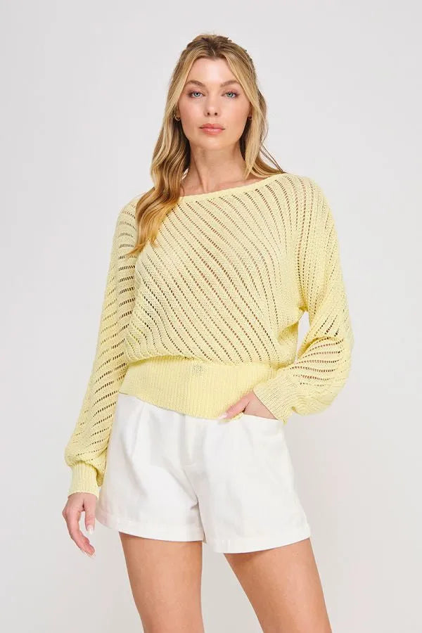 A soft yellow hand yarn open stitch dolman sweater top with a loose fit diagonal ribbed pattern and cropped hem