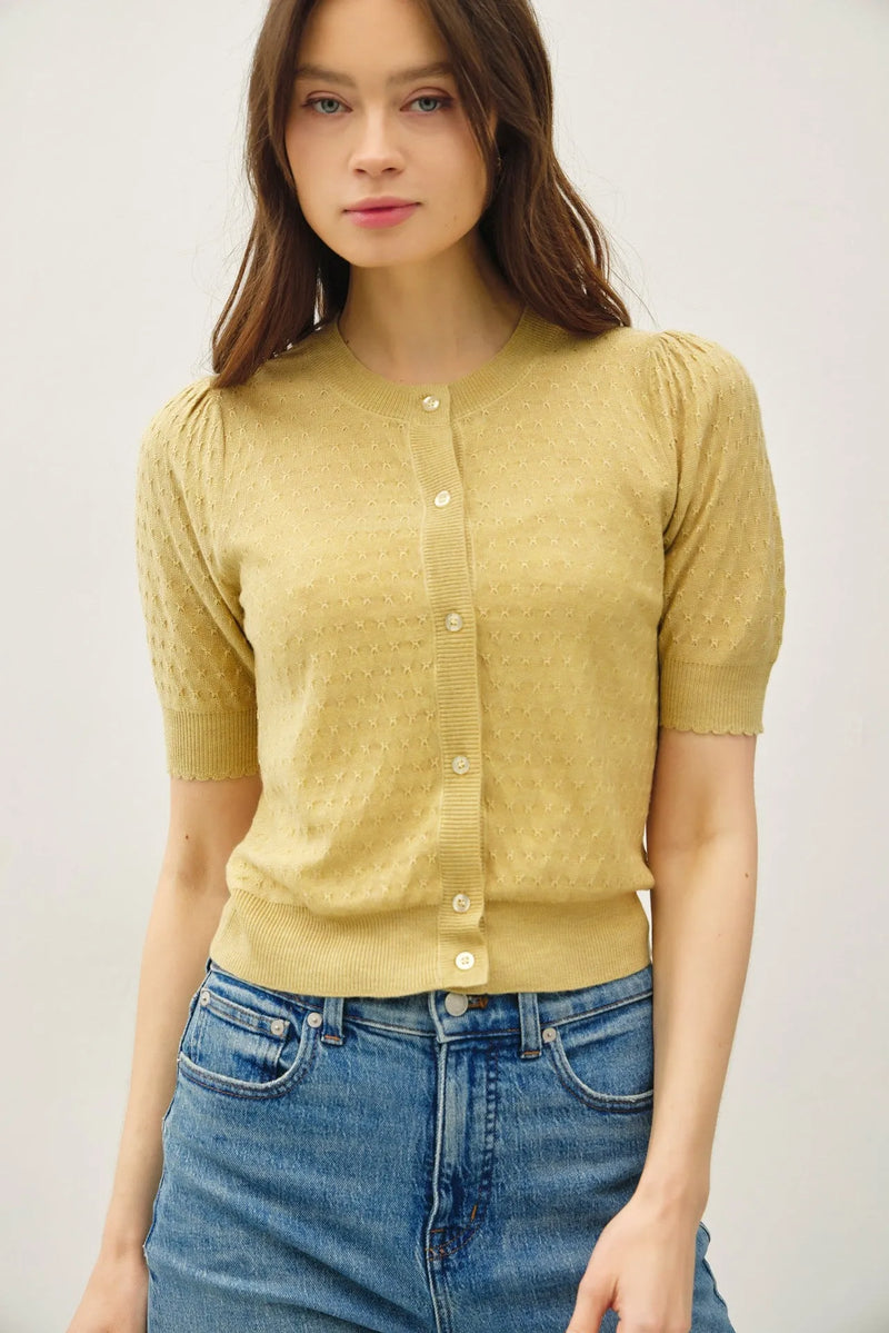 A soft yellow pointelle puff sleeve cardigan with short sleeves and button-front design in knitted fabric