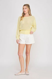 A soft yellow hand yarn open stitch dolman sweater top with ribbed texture and a slightly loose fit