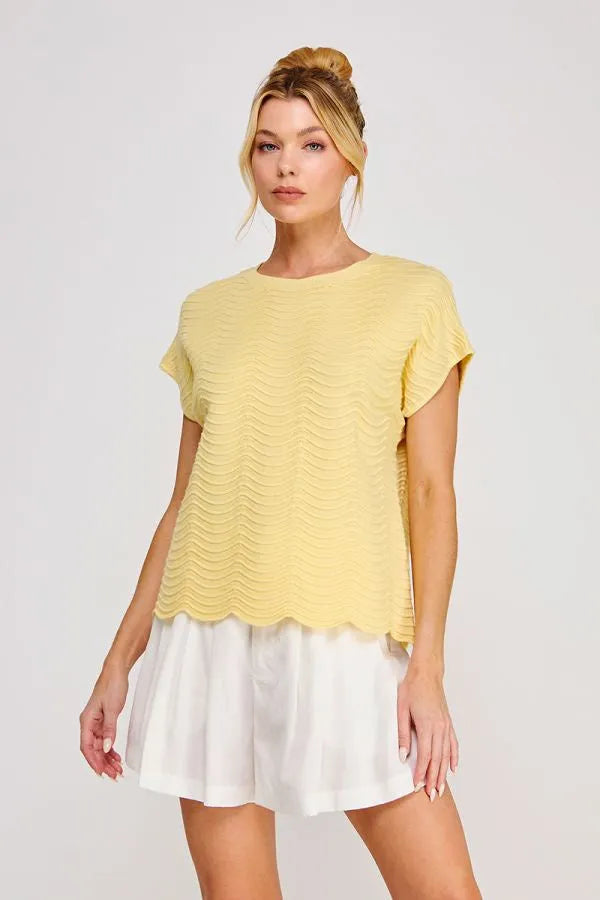 A soft yellow scallop pattern relaxed knit top with short sleeves and a scalloped hem for casual wear