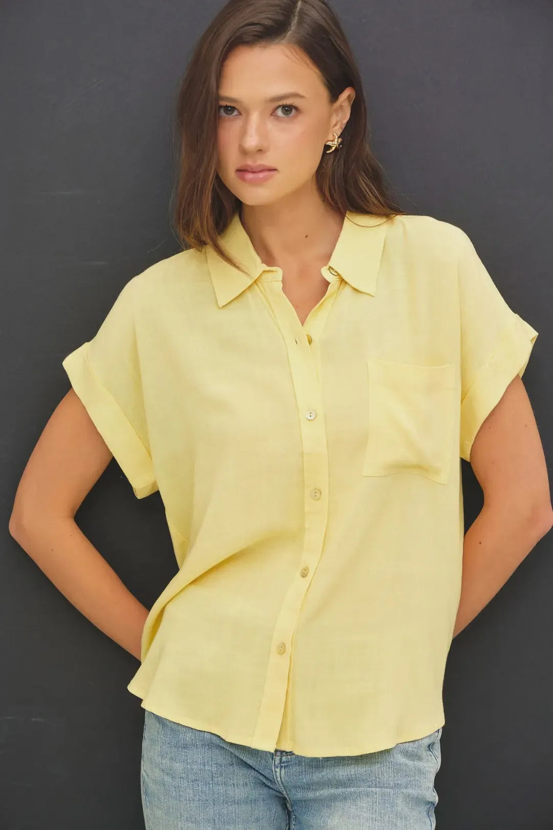 A soft yellow solid short sleeve button down shirt with relaxed fit and subtle pleats at the hem
