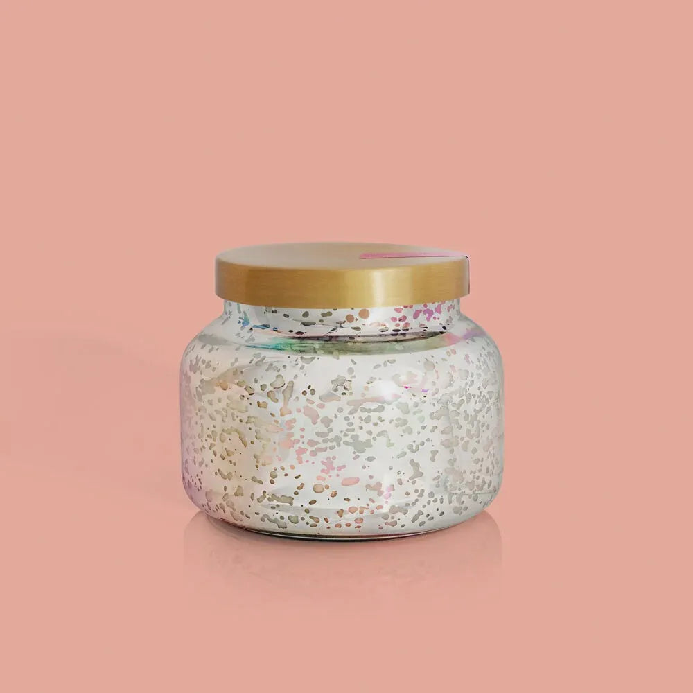 A mercury iridescent candle in a speckled glass jar with gold lid white wax and subtle pink silver flecks