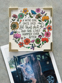 A cream-colored square corner magnet with a colorful floral design and wise girl phrase for women’s boho chic clothing