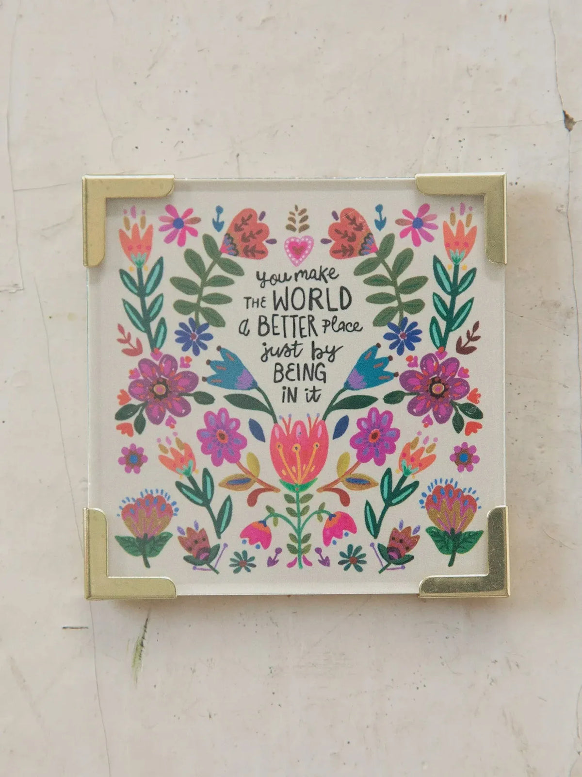 A square decorative corner magnet with a vibrant floral design and inspirational script on a white background