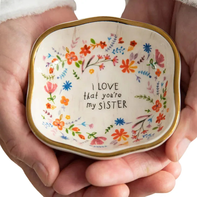 A square-shaped antiqued trinket bowl ceramic dish with gold rim floral patterns and sister inscription in black lettering