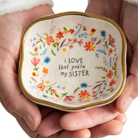 A square-shaped antiqued trinket bowl ceramic dish with gold rim floral patterns and sister inscription in black lettering