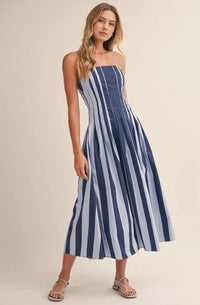 A strapless striped pleated flared midi dress in navy and light blue lightweight fabric with vertical stripes