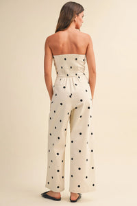 A strapless off-white polka dot stretch twill jumpsuit with smocked waistband and wide leg design