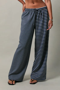 Low rise stripe front tie pants in navy and white striped wide-leg fabric with elastic waist and drawstring closure