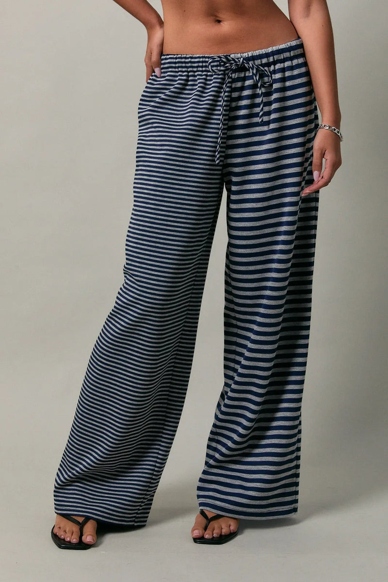 Low rise stripe front tie pants in navy and white striped wide-leg fabric with elastic waist and drawstring closure