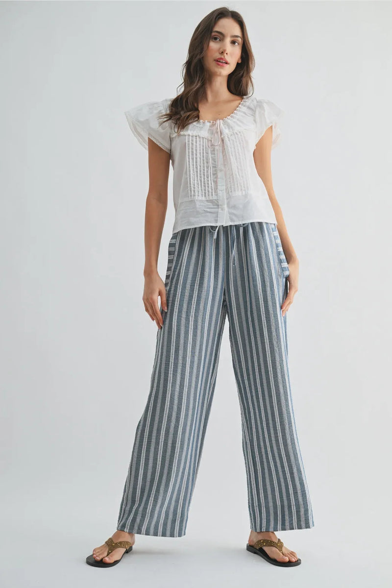Striped wide leg drawstring pants in soft blue and white vertical stripes made from lightweight fabric with a relaxed fit