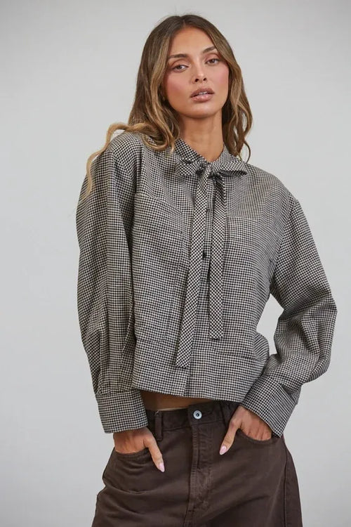 A stylish black and white plaid bow tied collar shirt featuring a tied collar bow at the neckline