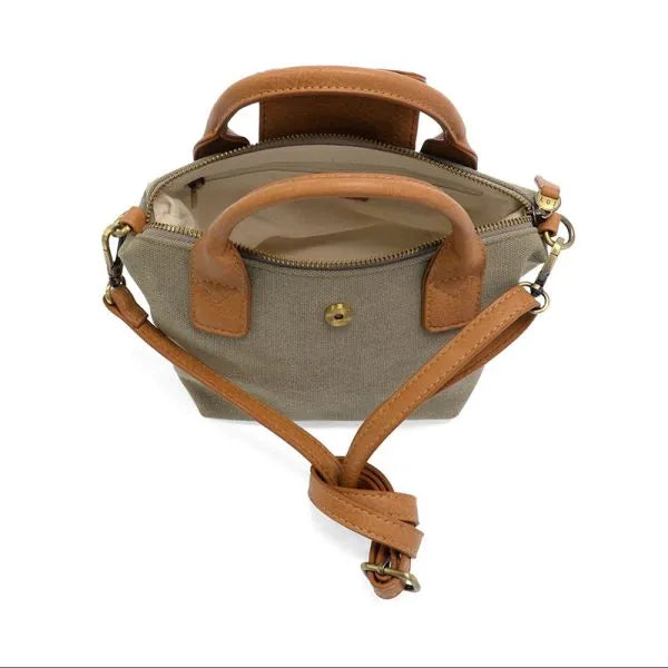Tan leather handle and strap on beige canvas abilene canvas mini tote crossbody handbag with compact design
