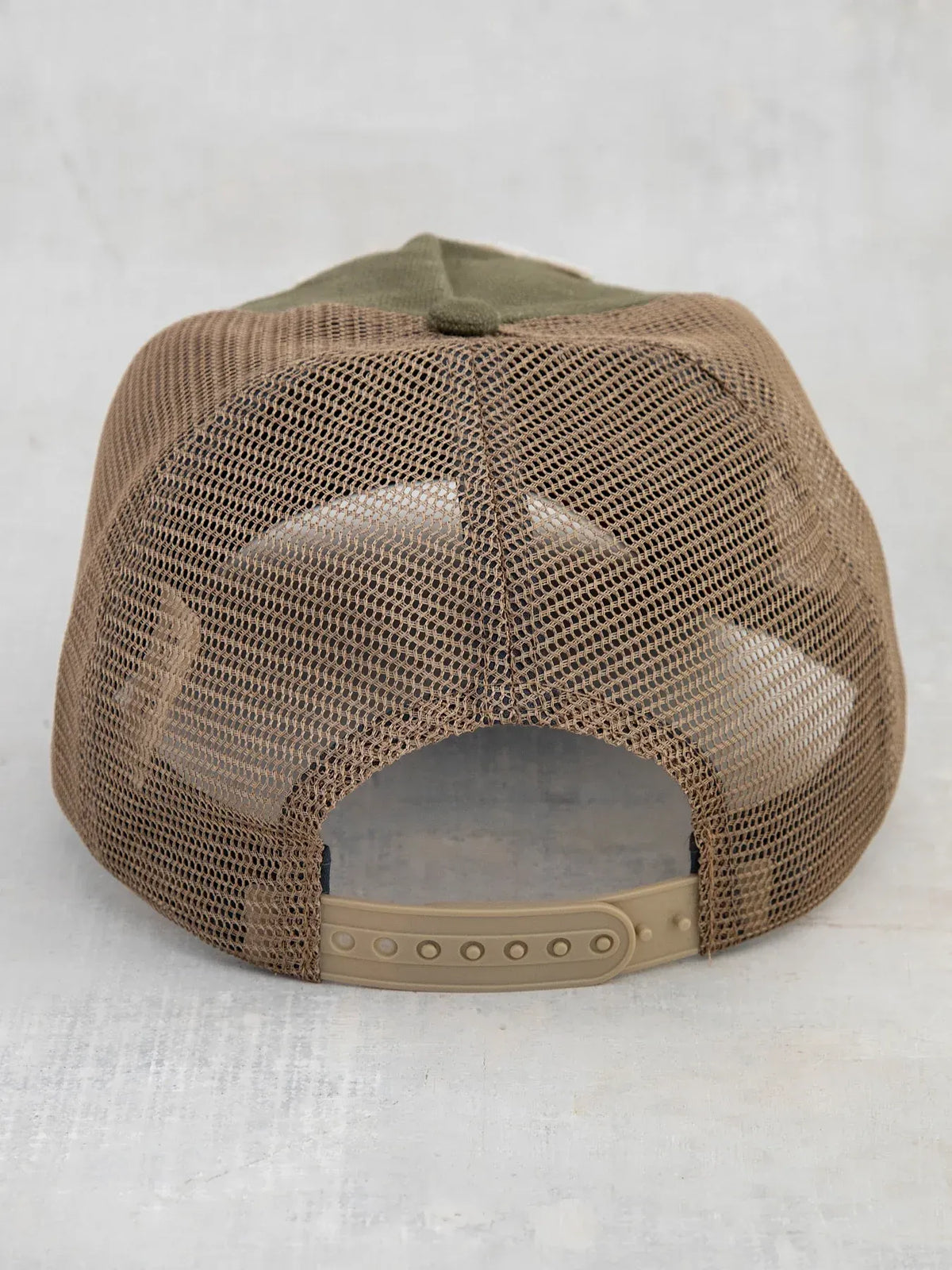 Tan mesh canvas trucker hat with olive green fabric panels and beige adjustable strap for outdoor use