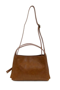 A tan suede grace satchel crossbody with slender adjustable strap and dual top handles for versatile wear