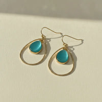 Elegant gold teardrop hoop earrings featuring teal cats eye stone cabochons and gold-toned wireframe design