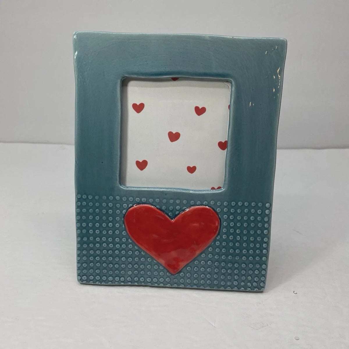 Teal stoneware heart icon ceramic picture frame with textured surface featuring large and small red hearts on white background
