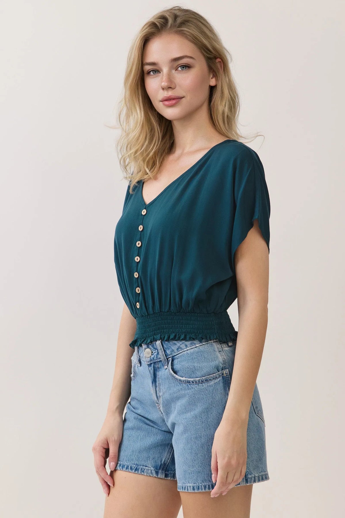 Teal v neck button detailed blouse with short flutter sleeves and smocked waistband in lightweight fabric
