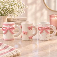 Three white stoneware mugs with 3d pink bow design and polka dots for enjoying favorite hot beverages