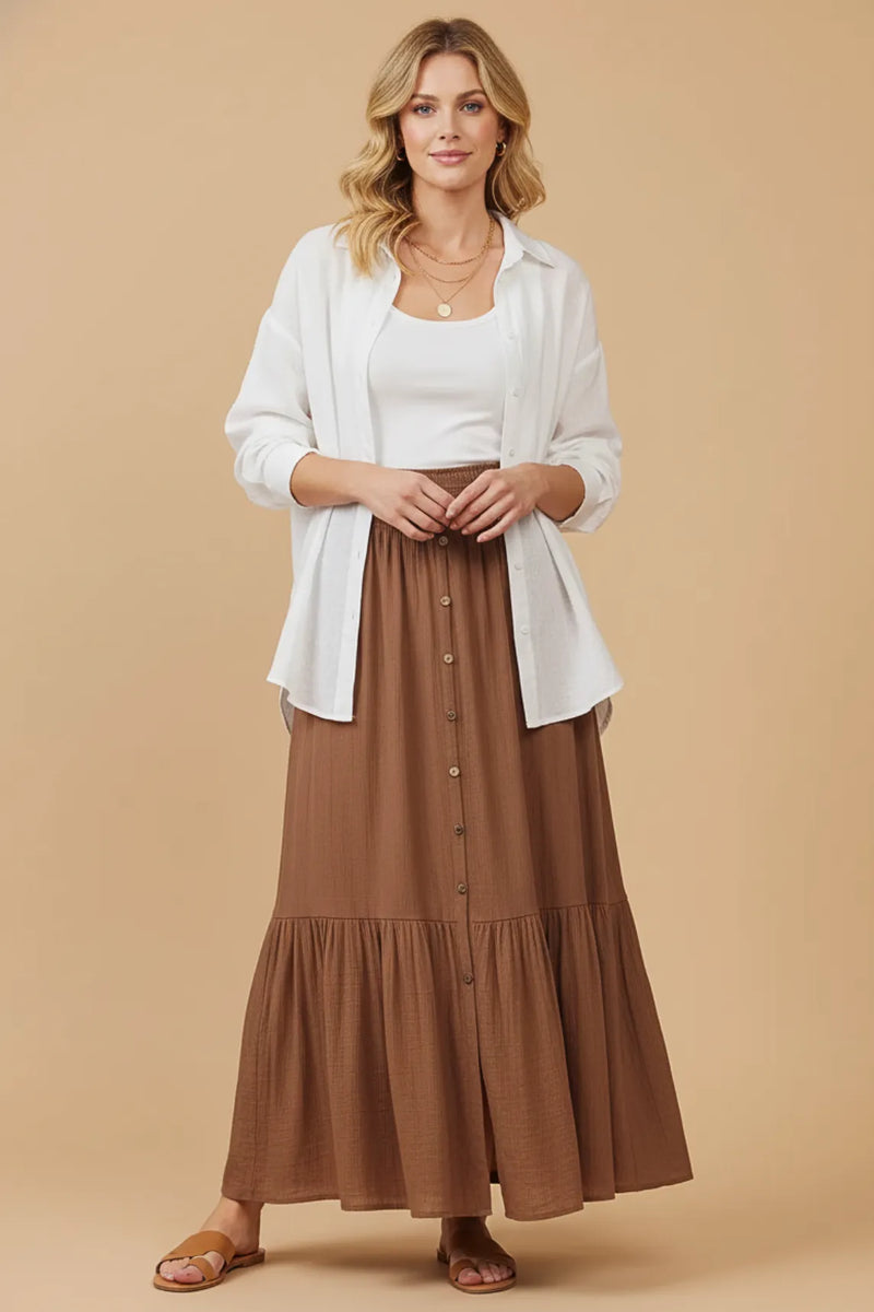 A flowing brown tiered center slit maxi skirt with button-front design and elastic waistband