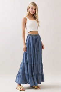 A flowing tiered maxi skirt in denim with tencel elastic waisted drawstring and subtle fading