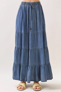 A flowing blue tiered maxi skirt made of tencel with elastic waisted drawstring and subtle frayed hem