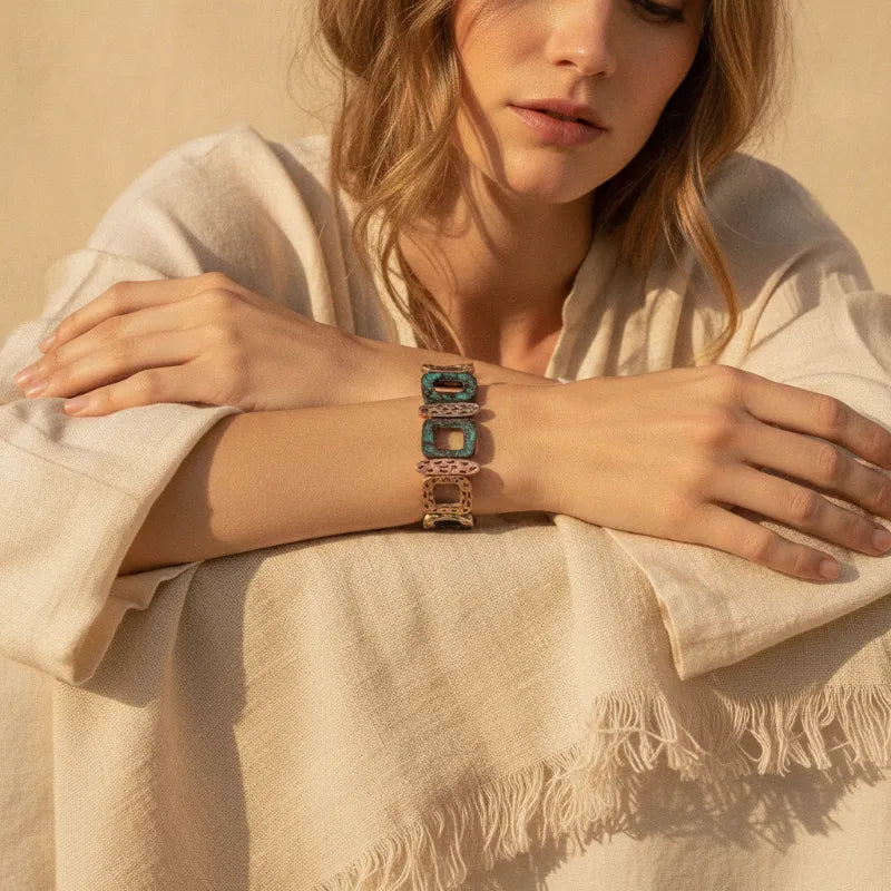 A turquoise and gold-toned metal patina geometric stretch bracelet with intricate openwork design
