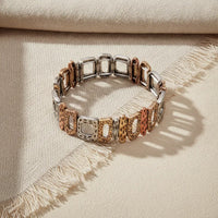 Elegant artisanal textured stretch statement bracelet with alternating silver and rose gold cut-out square links