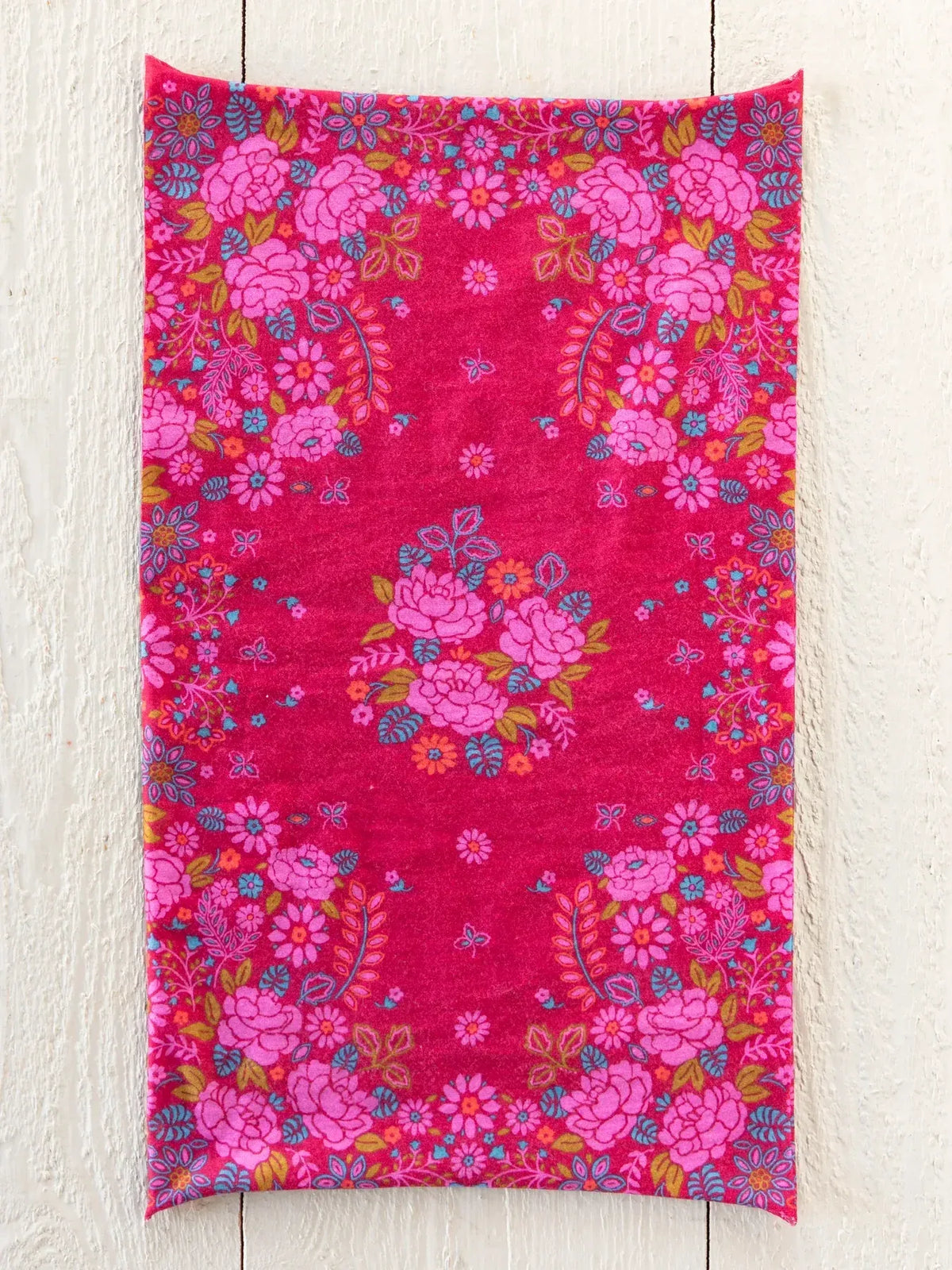 A vibrant fuchsia boho bandeau headband featuring dense floral patterns with pink roses blue and orange accents and butterflies