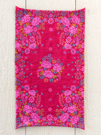 A vibrant fuchsia boho bandeau headband featuring dense floral patterns with pink roses blue and orange accents and butterflies