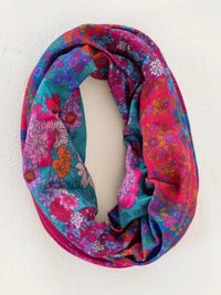 A vibrant multicolored floral infinity scarf with soft fabric texture in jewel positano scarf boho bandeau style